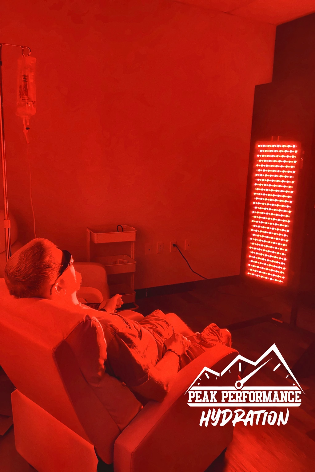A client under the red light therapy panel at Peak Performance Hydration