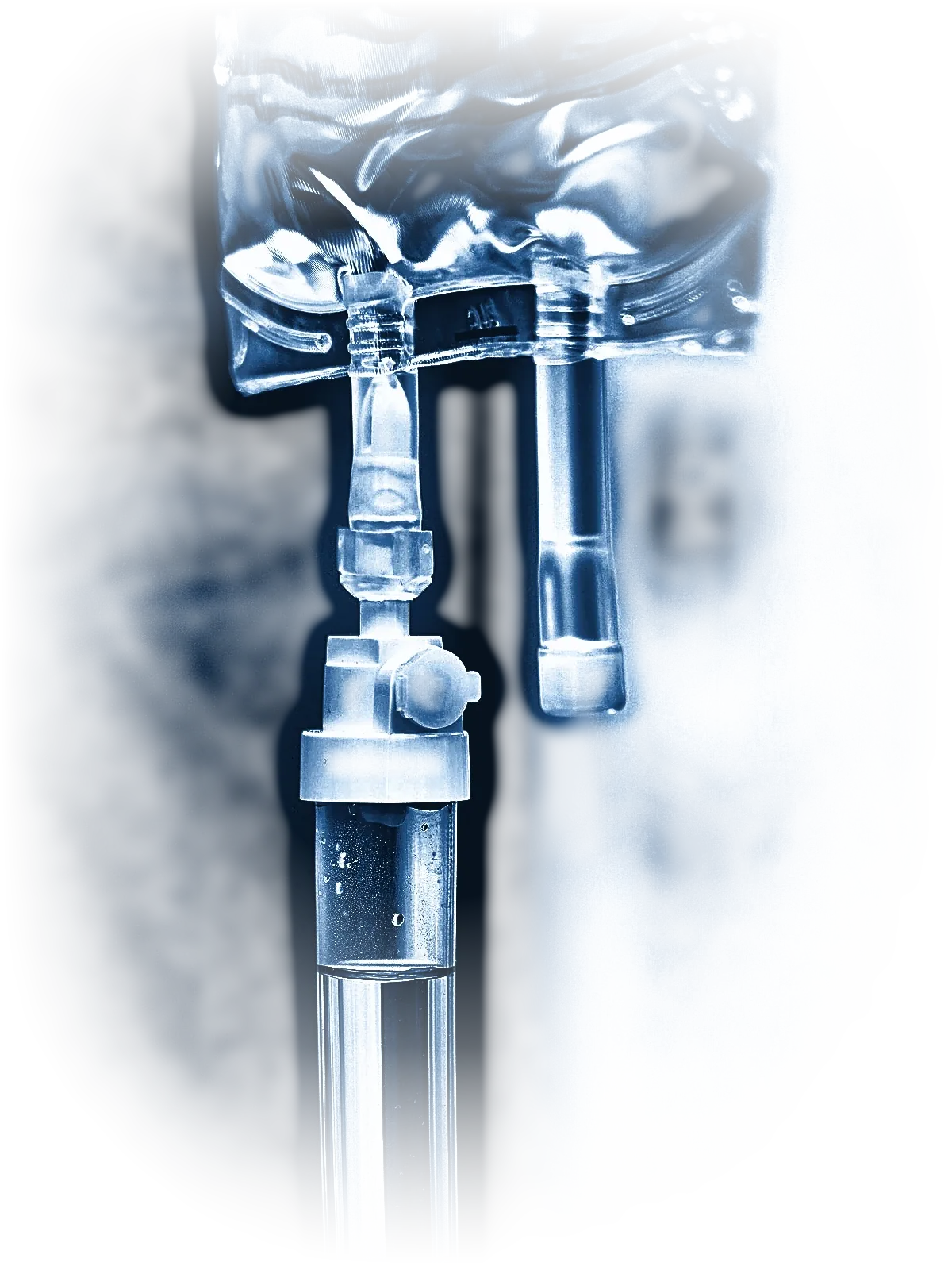 An IV bag and drip chamber lit against deep navy