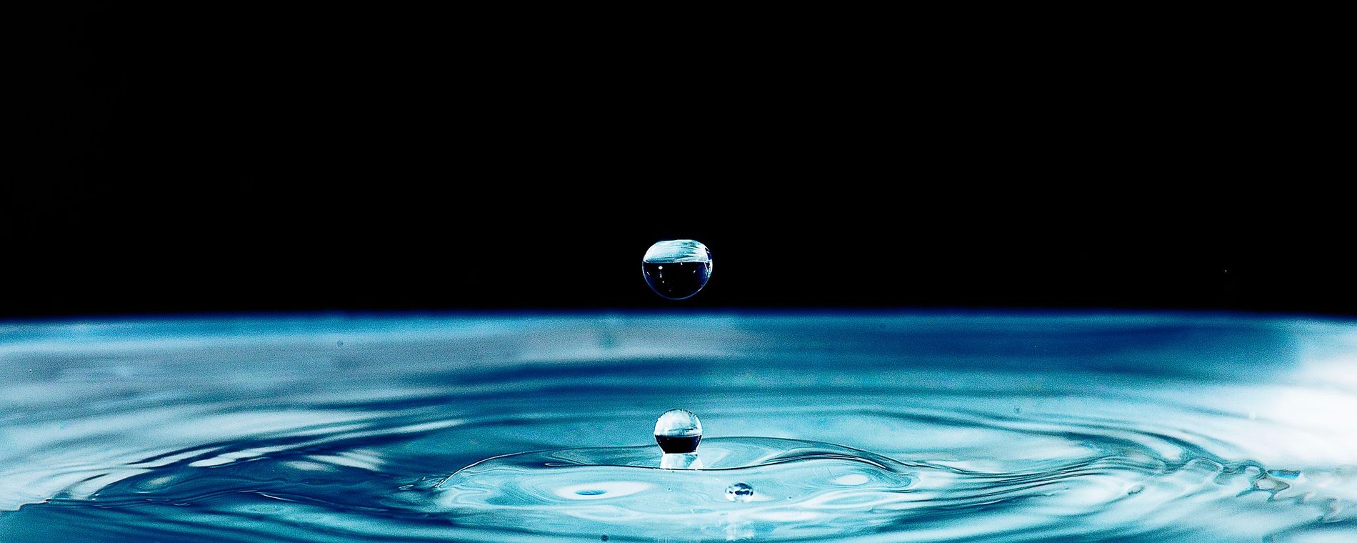 A droplet bouncing off a sheet of blue water